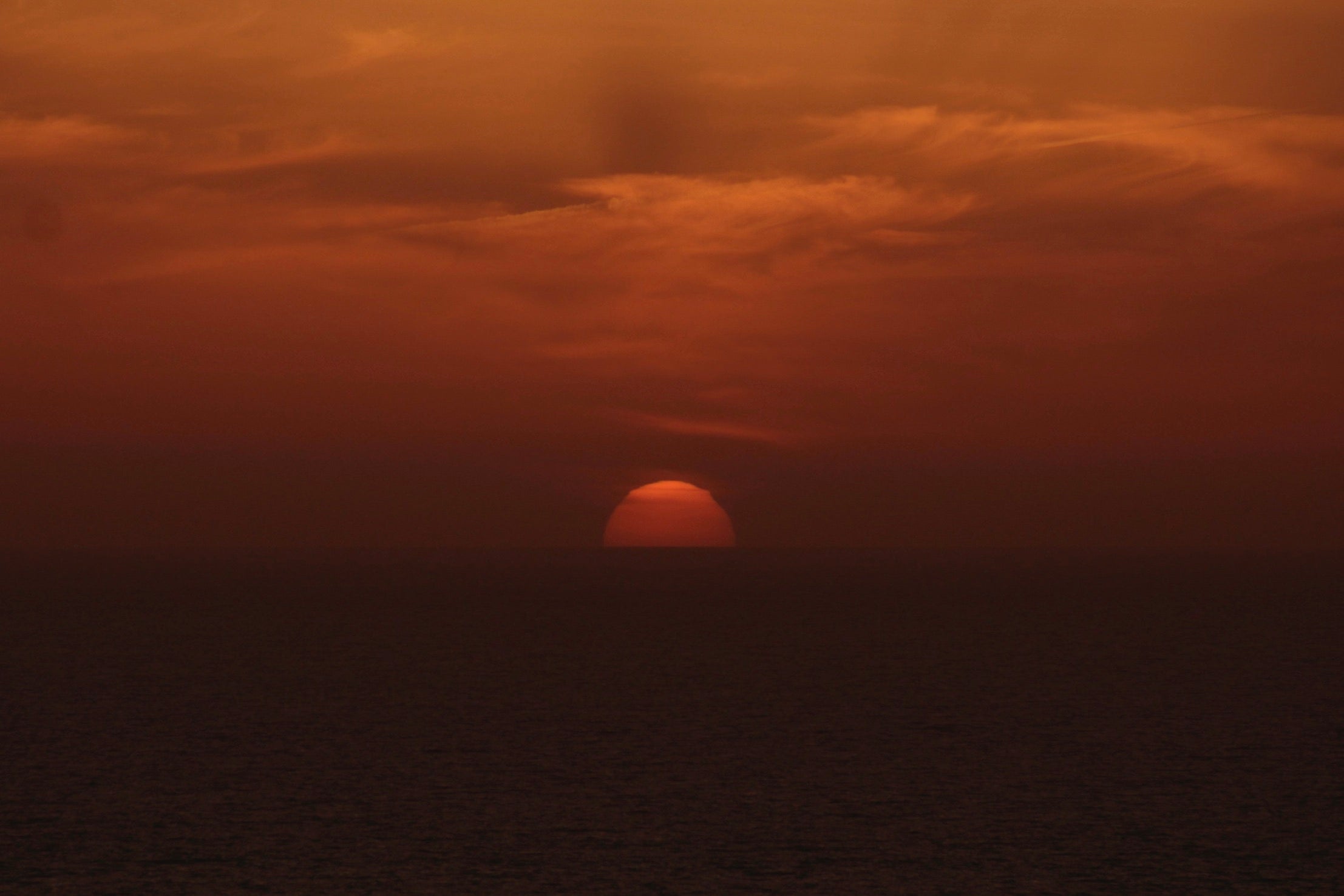 Sunset over water with a reddish-orange sky